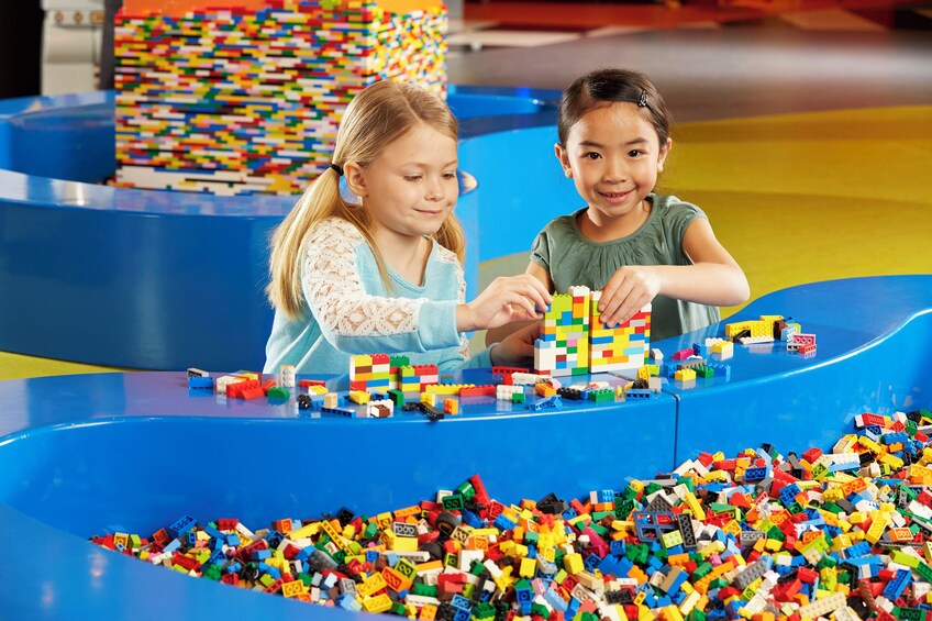 Two children playing with colorful building blocks on a blue play table. 5