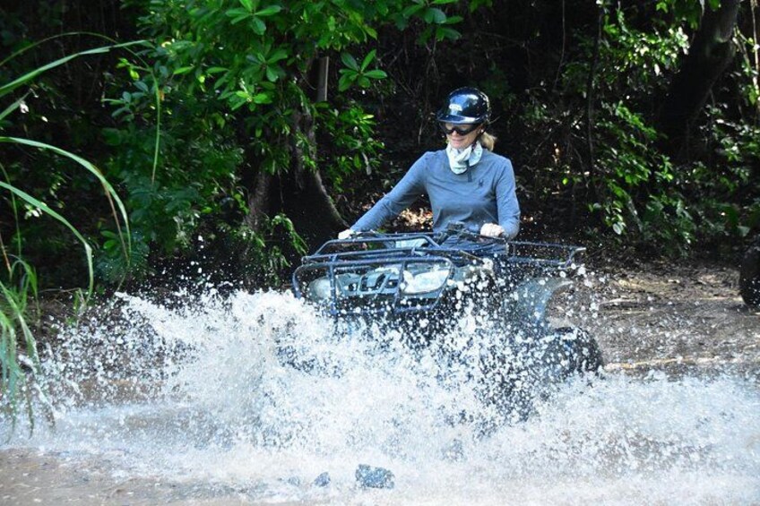 A person riding a jet ski through a body of water surrounded by greenery. 5
