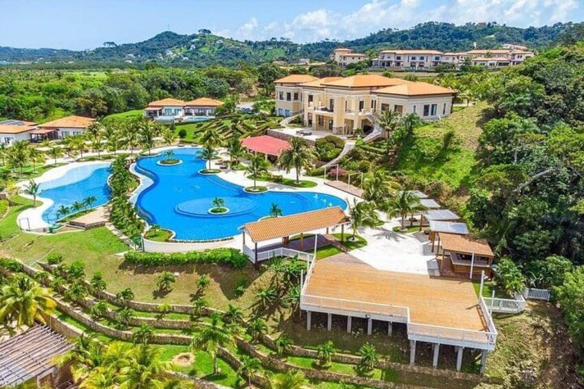 A resort with multiple swimming pools, villas, and lush greenery. 3