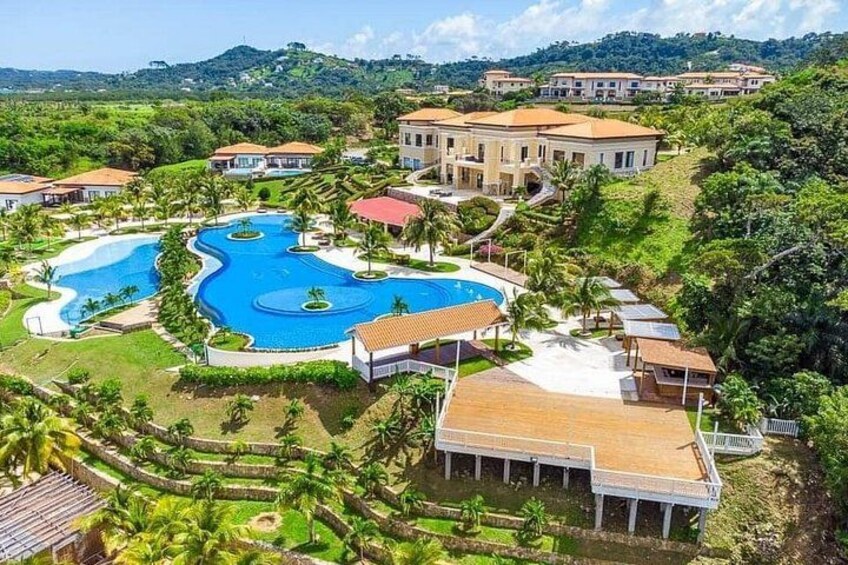 Ein Resort mit mehreren Schwimmbecken, Villen und üppiger Bepflanzung. 4