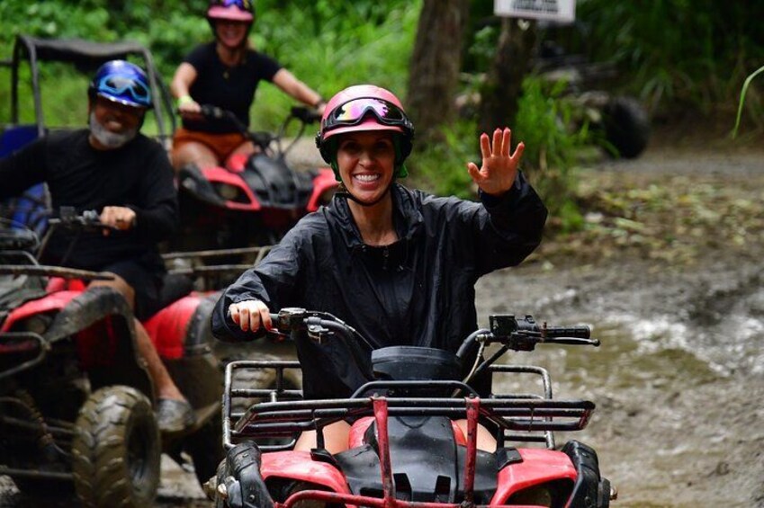 People riding atv's on a muddy path. 2