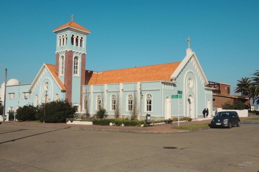 A church with a bell tower, a dome, and a red-tiled roof. 3