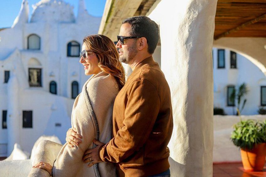 Un couple se tient devant un bâtiment blanc doté de fenêtres en arc de cercle et d’un dôme. 3