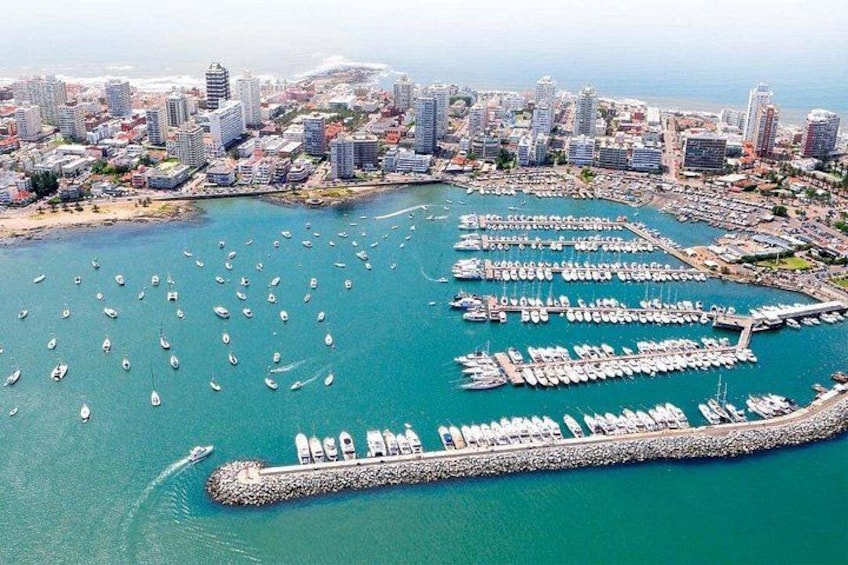 Une ville côtière dotée d’un port de plaisance rempli de bateaux, d’une longue jetée et d’immeubles de grande hauteur. 2