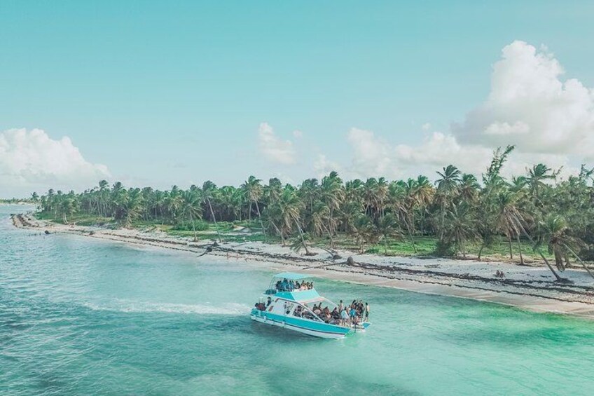 A boat on turquoise water, a sandy beach, and a line of palm trees. 5