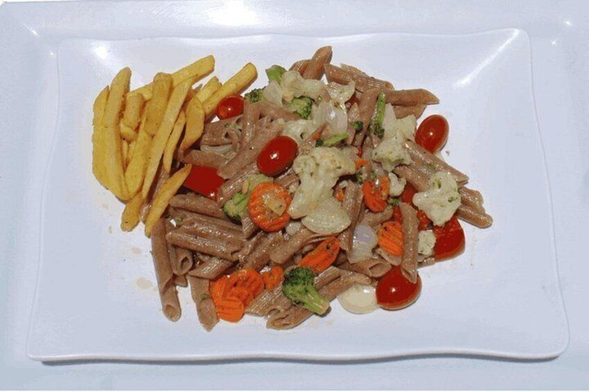 A plate of pasta with vegetables and fries. 4