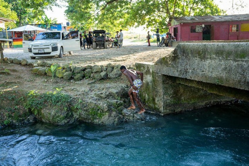 A person jumping into a river from a concrete ledge. 5