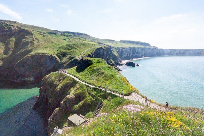 A coastal landscape with a narrow footpath, cliffs, and a body of water. 5