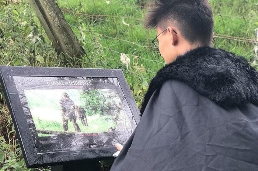 Una persona sosteniendo un cuadro enmarcado de Juego de Tronos. 2