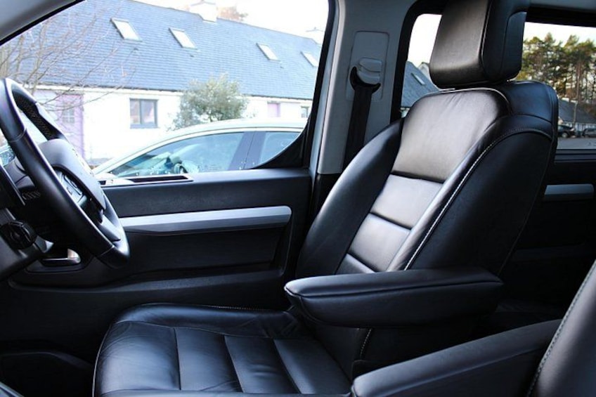 A car interior with black leather seats and a steering wheel. 3
