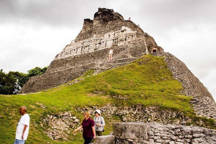 A large ancient pyramid with a grassy hill in the foreground. 1