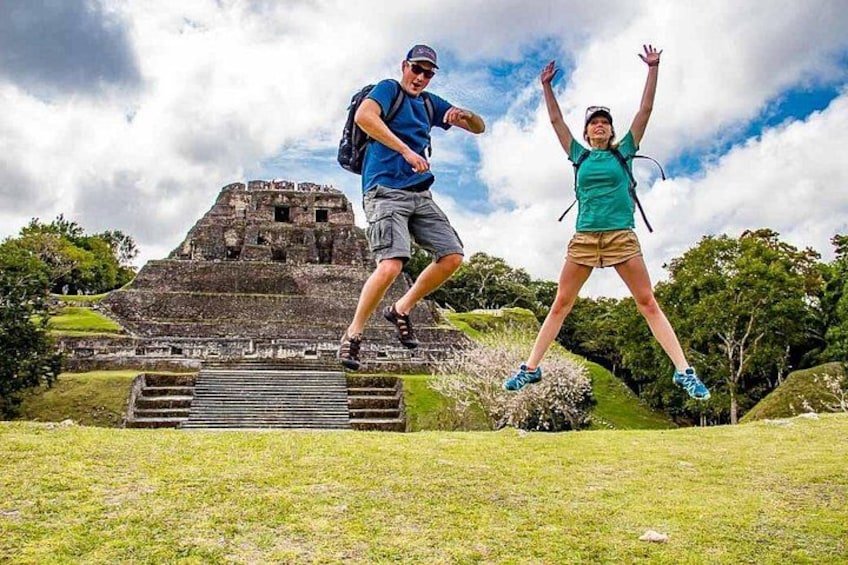 Two people jumping in front of a Mayan pyramid. 1