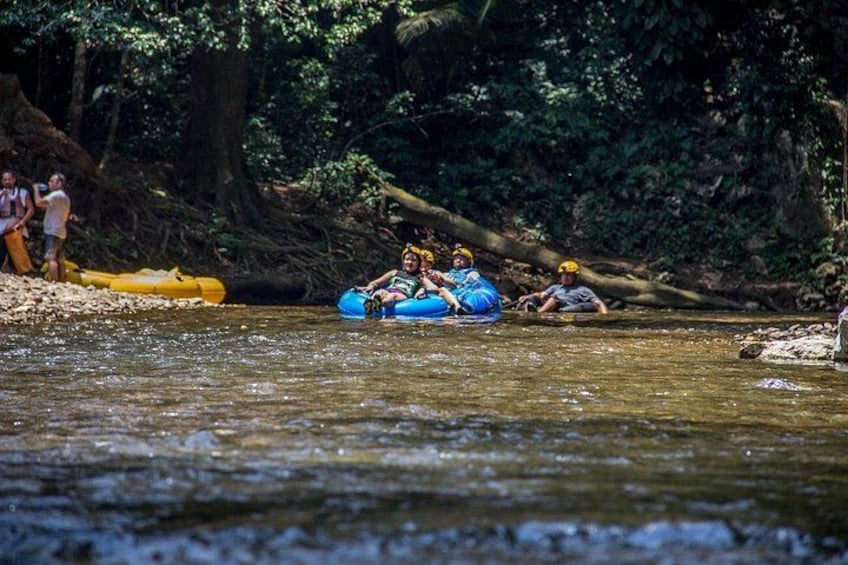 People rafting on a river surrounded by dense forest. 1