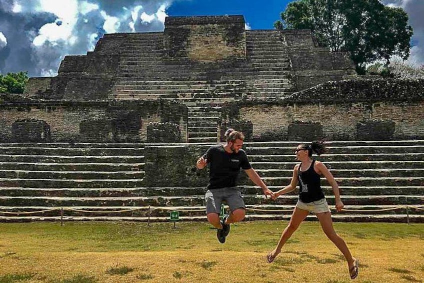 Two people jumping in front of an ancient stone structure. 3