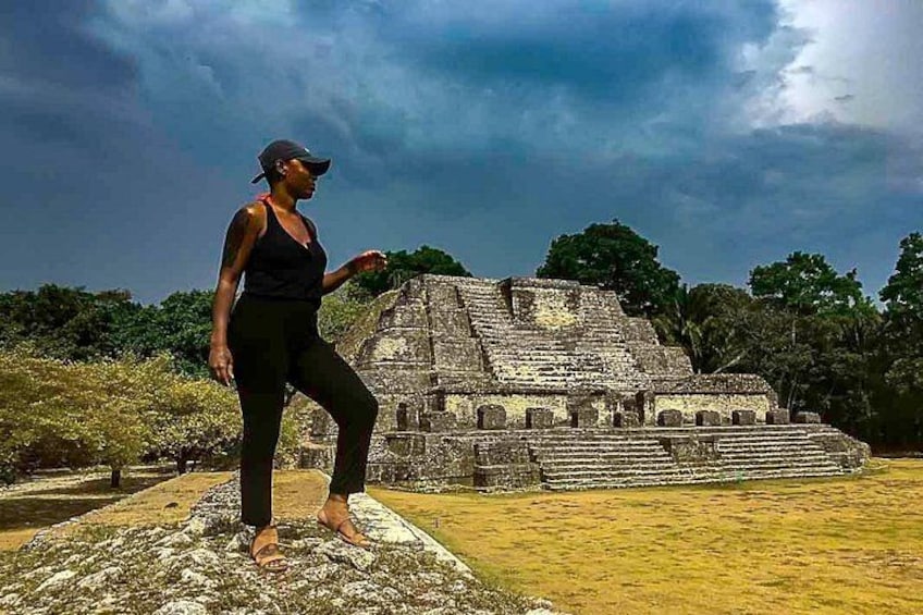 A person standing in front of a large ancient pyramid structure. 2