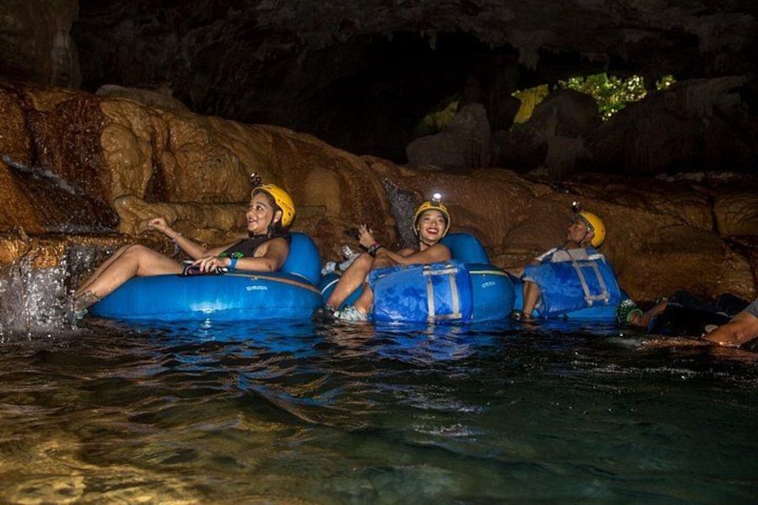 People in blue inflatable tubes in a water body with rocky surroundings. 4
