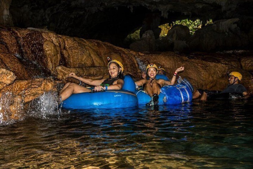 Personas flotando en un cuerpo de agua rodeado de rocas. 2