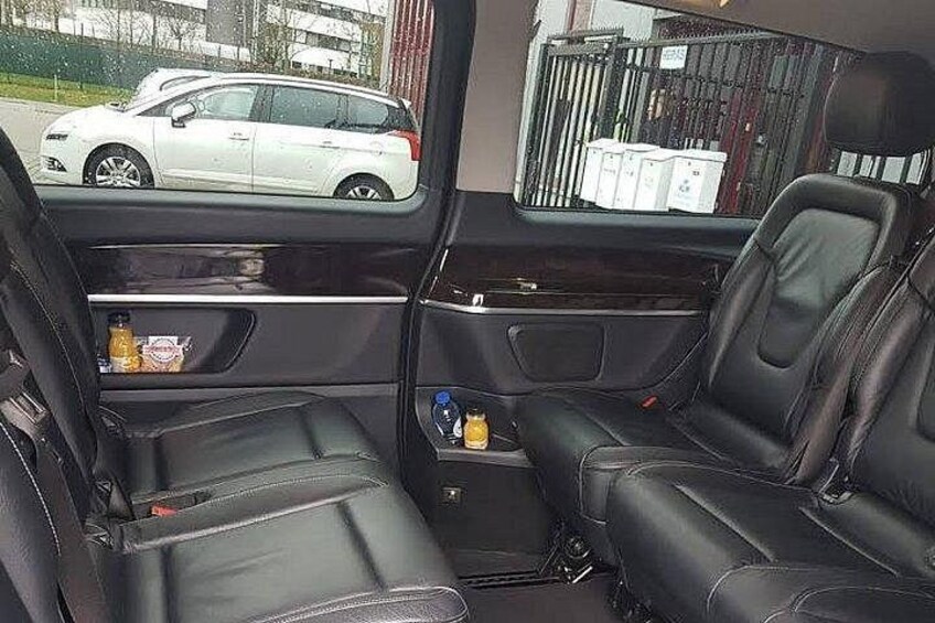 A vehicle interior with leather seats, a center console, and a rearview mirror. 2