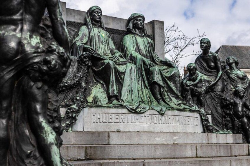 A bronze statue of a seated man and woman with a child, with inscriptions on the base. 2
