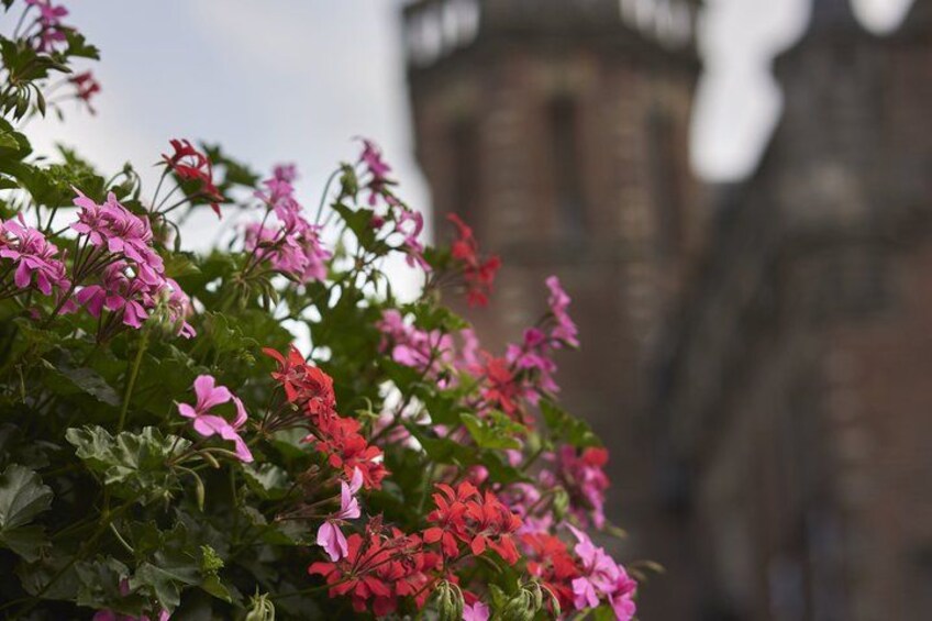 Pink and red flowers in front of a historic building. 3