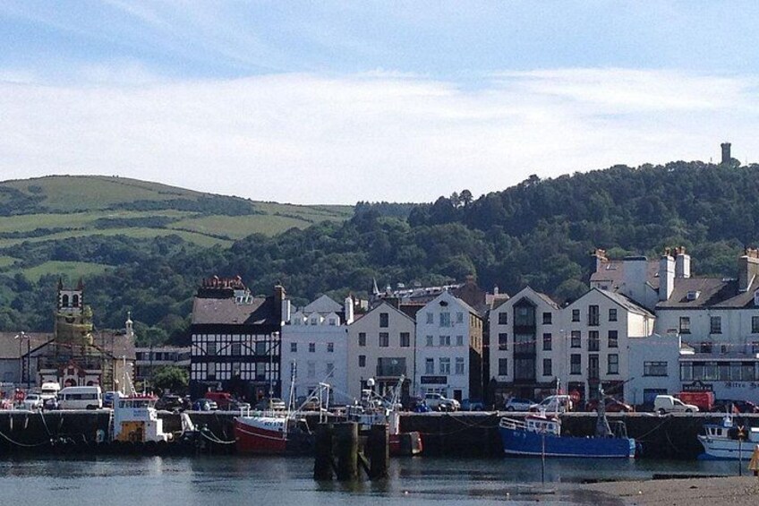 A harbor with boats, a church, and buildings along the waterfront. 4