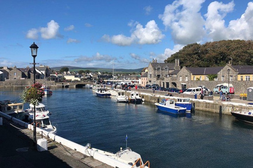 A harbor with boats docked, a bridge, and buildings along the waterfront. 2