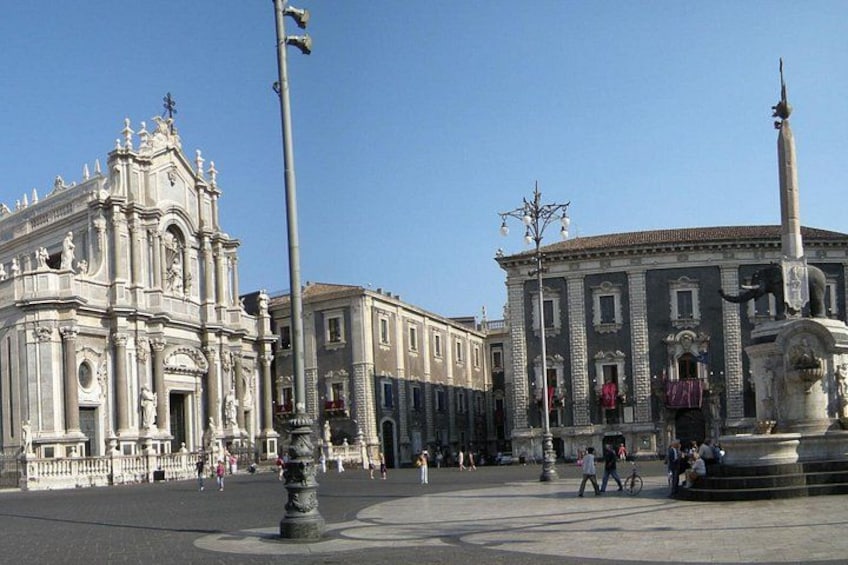 A historic plaza with a prominent church and a fountain. 3