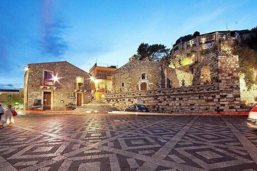 Un edificio storico in pietra con un lastricato in pietra davanti. 3