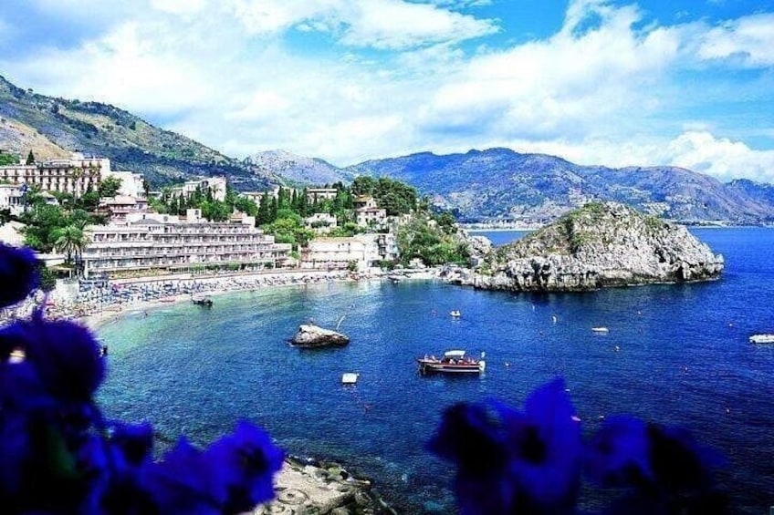 Una cittadina costiera con edifici, barche e un'isola rocciosa. 4