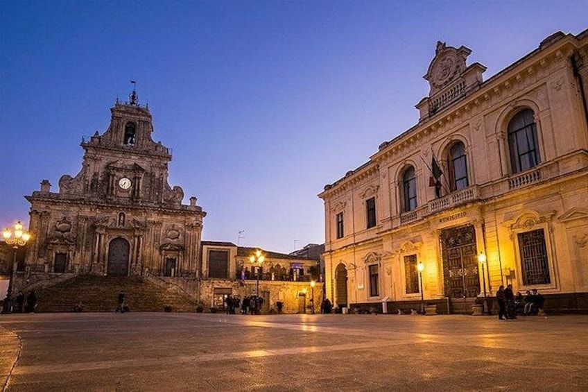 A historic plaza with a church and a government building. 2