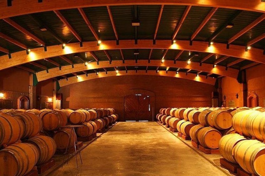 Una bodega con barricas de madera dispuestas en filas. 1