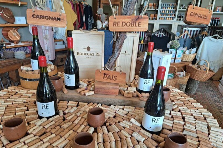 Botellas de vino con etiquetas que incluyen nombres como 'CARIGNAN' y 'RE DOBLE', rodeadas de tapones de corcho. 4