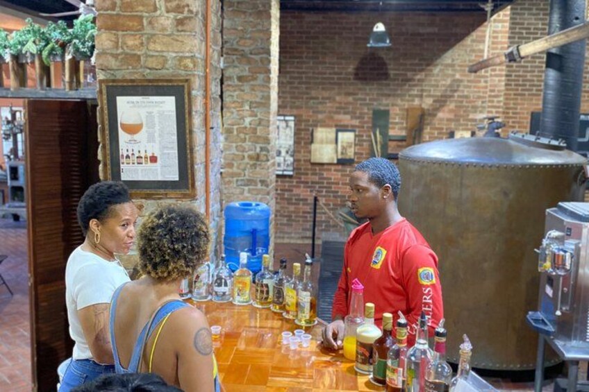 Un bar con un cantinero, una barra de madera y varias botellas. 1