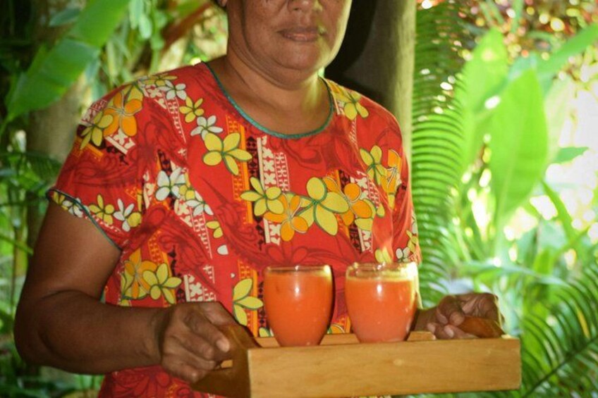 En person holder en bakke med to glas appelsinjuice. 4