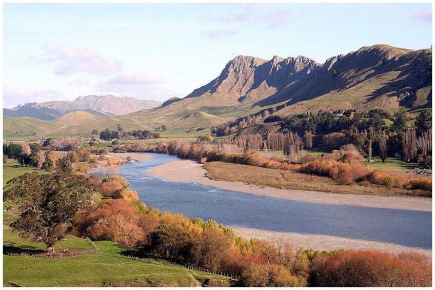 Un río serpentea por un valle con montañas al fondo. 4