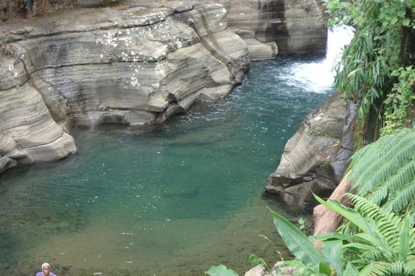 A river flowing through a rocky gorge with clear water and lush greenery. 2