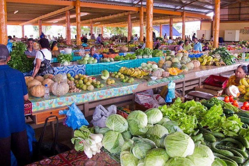 A bustling indoor market with various fresh produce displayed on tables. 4