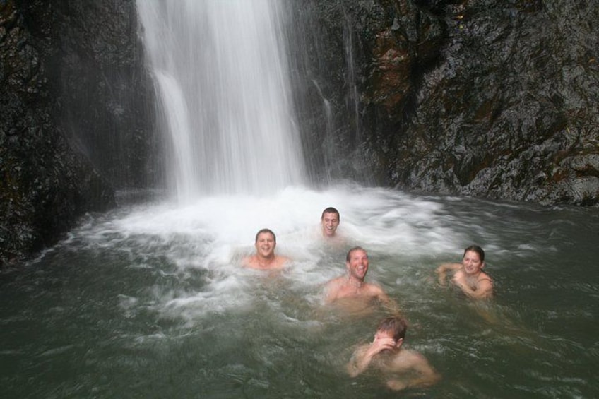 A waterfall with people in a natural pool. 5