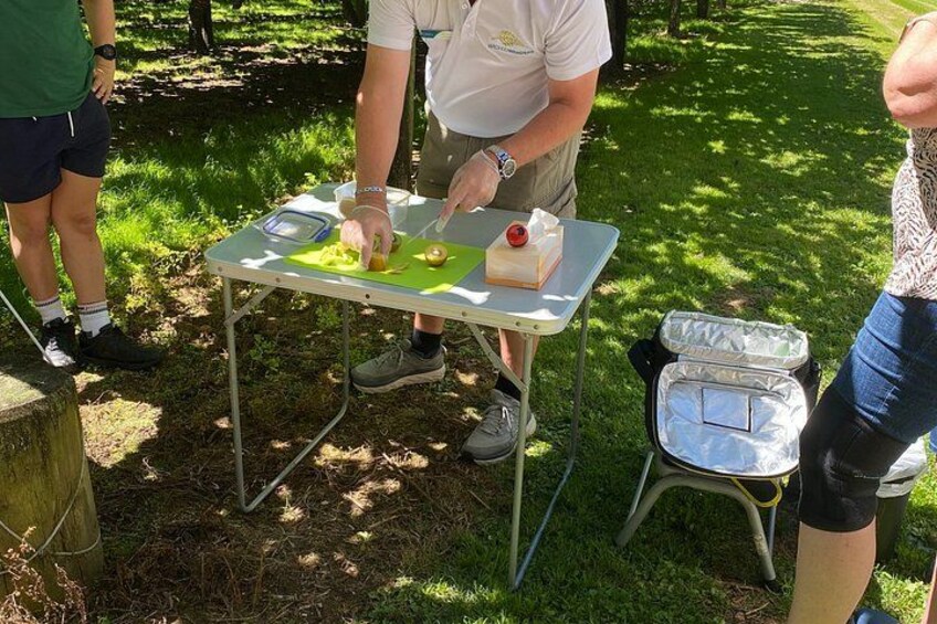 A person preparing food outdoors on a portable table. 2