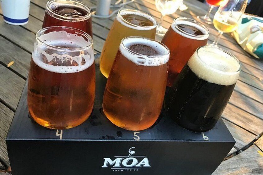 En sort kasse med 'MOA'-logo og fem ølglas ovenpå. 3