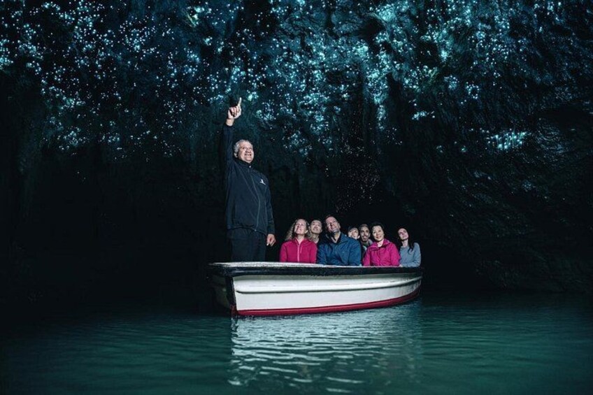 A boat with people on a body of water, surrounded by trees. 1