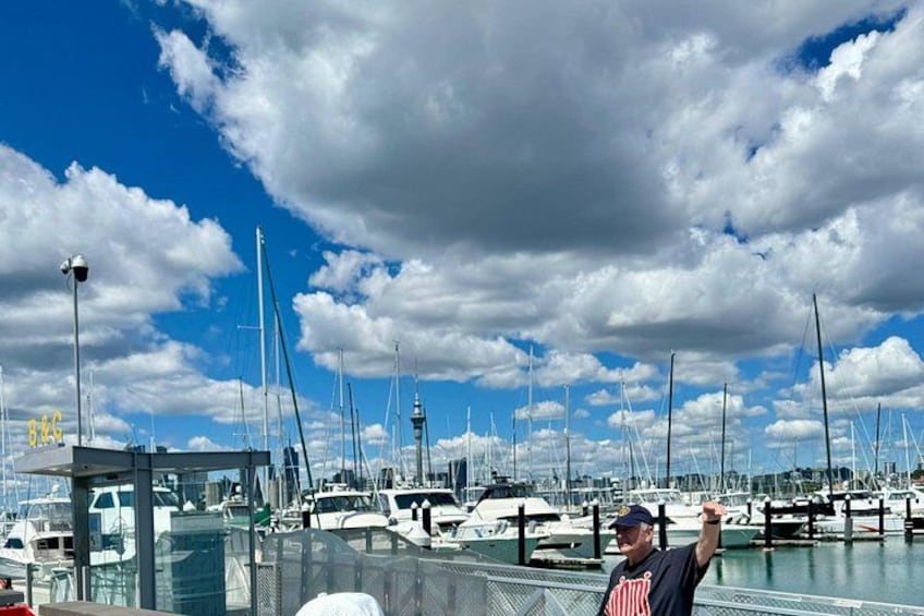A marina with multiple boats docked, a clear sky, and a person standing on a dock. 5