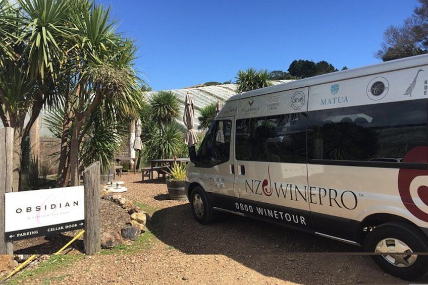 Un fourgon blanc arborant le logo « NZ Wine Pro » était stationné dans une zone viticole, au milieu de palmiers, à proximité d’un panneau indiquant « Obsidian Cellar Book ». 3