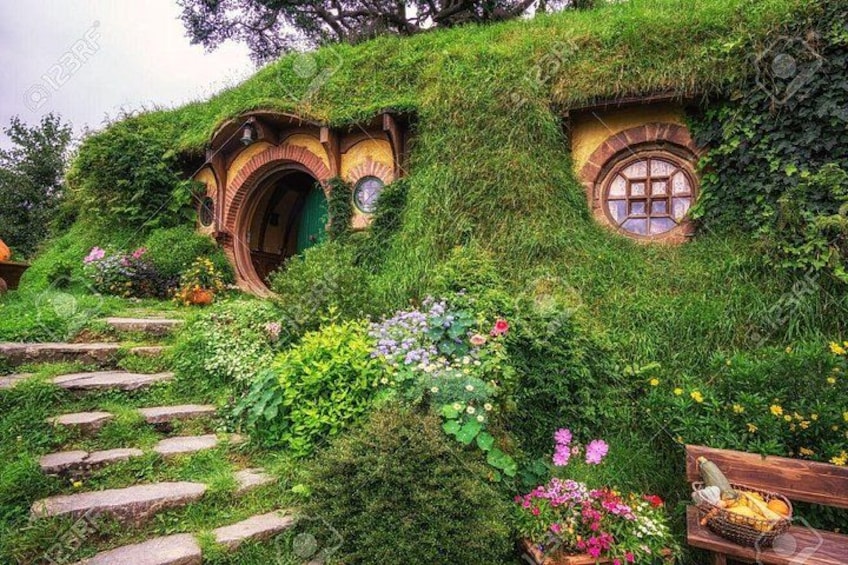 Casas de estilo Hobbit con tejados de hierba, una escalera de piedra y una cesta de fruta. 2