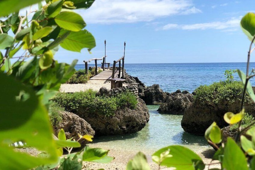 A rocky coastal area with a wooden walkway leading to a small platform. 4