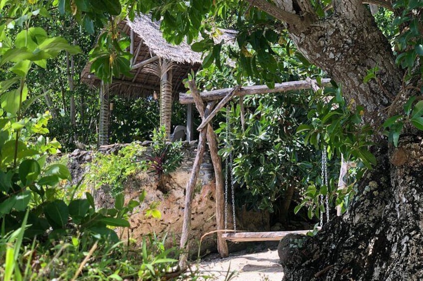 A rustic wooden structure, a tree, and dense foliage. 2