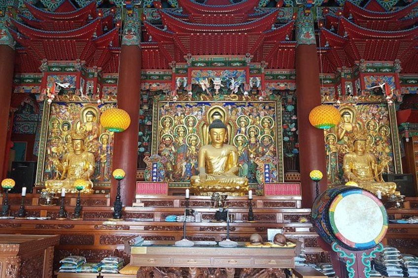 Innenraum eines Tempels mit goldenen Buddha-Statuen, filigranen Schnitzereien und traditioneller chinesischer Architektur. 3