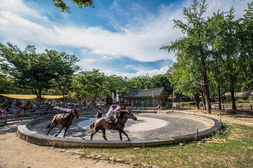 Un événement équestre où des cavaliers montent à cheval dans une arène circulaire entourée d’arbres. 2