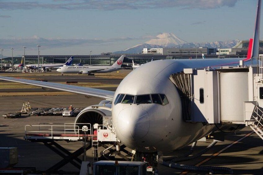 An airplane at a gate with a mountainous background. 5