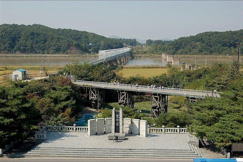 A bridge over a river, surrounded by greenery and hills. 3
